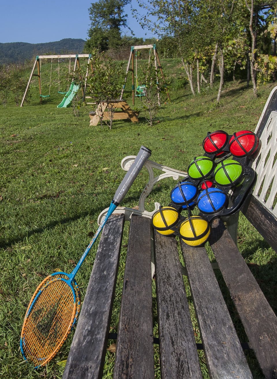 Play area with 3 swings, slide, sandpit, badminton and other outdoor games
