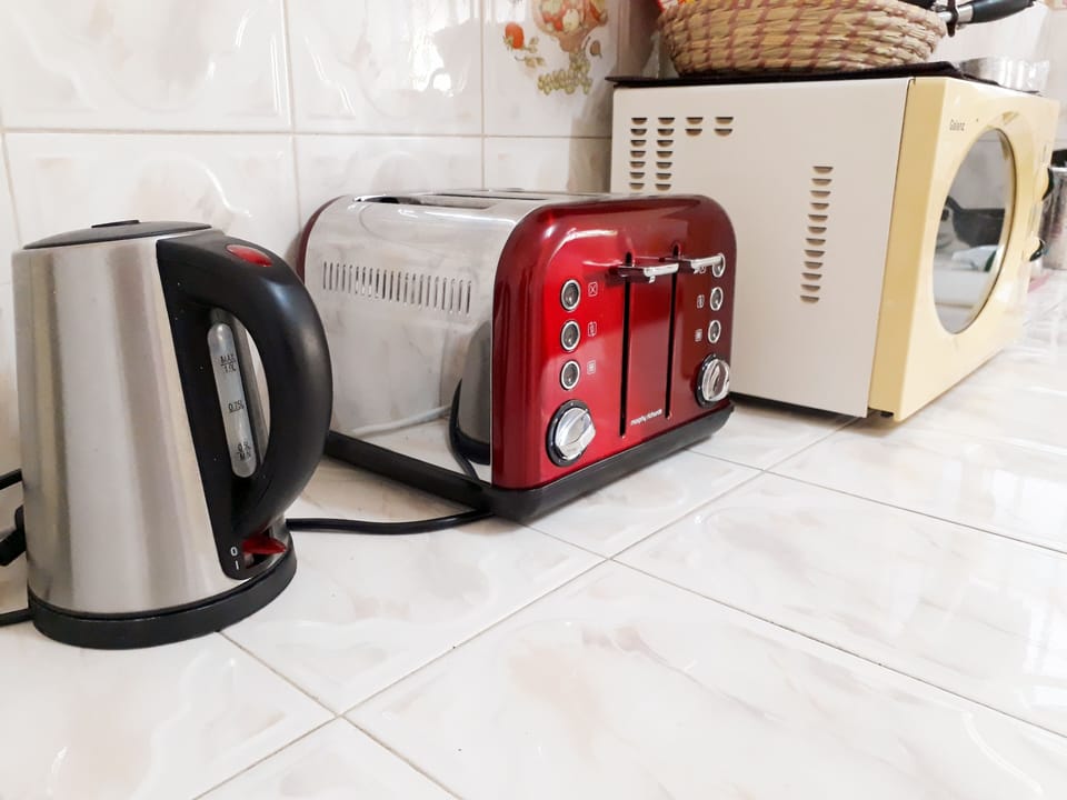 Kitchen with fridge freezer, gas stove, microwave, kettle, toaster, french press