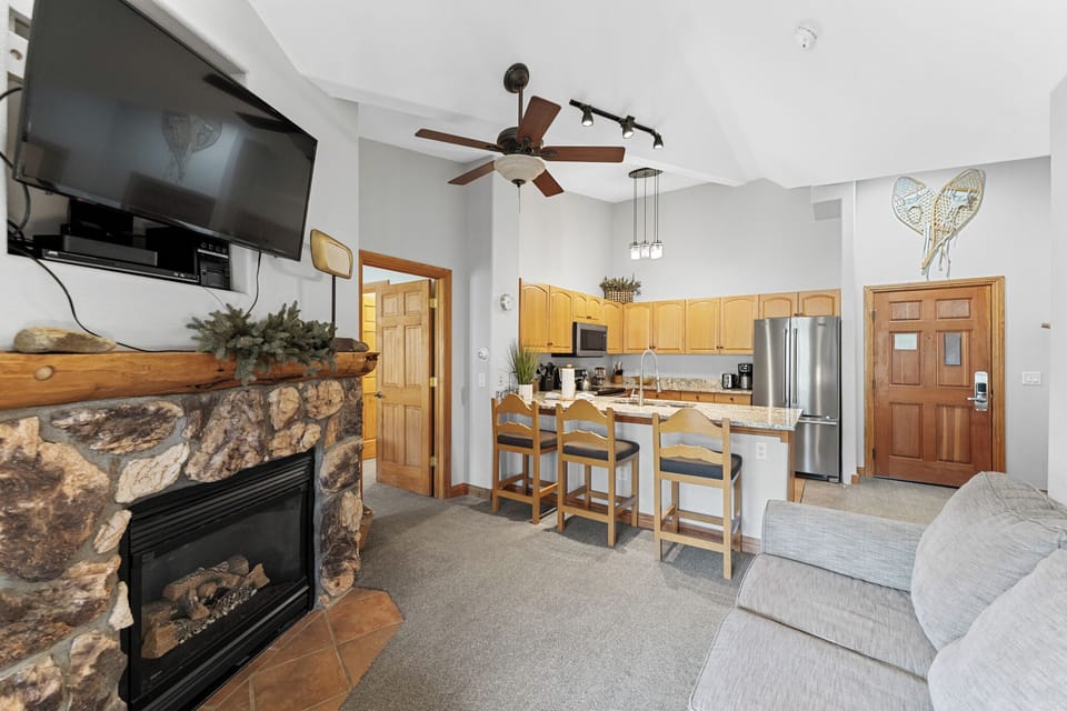 Living area featuring a mounted TV over a gas fireplace, and queen sleeper sofa.
