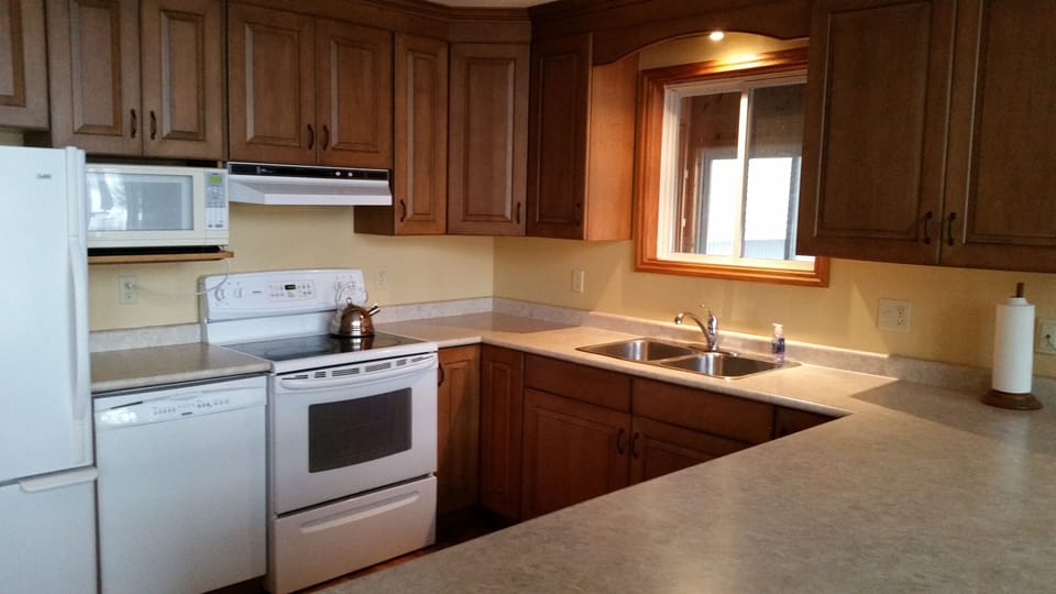 Kitchen -  two fridges, microwave, dishwasher, stove, double sink.  