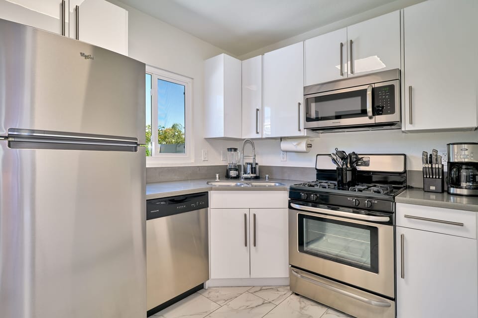 Kitchen with gas range, dishwasher and exit to private backyard. 