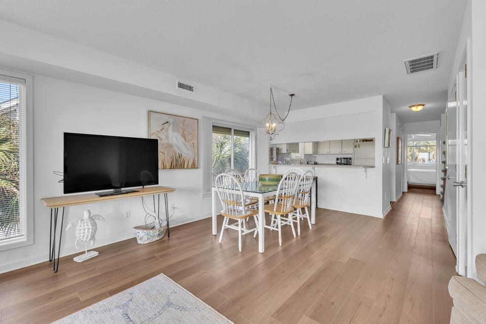 Your bright, open living space flows seamlessly from cozy TV area to dining table, creating the perfect gathering spot for meals and relaxation.