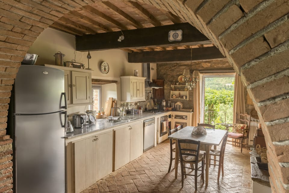 Kitchen with french windows to lovely dining terrace with views over the valley.