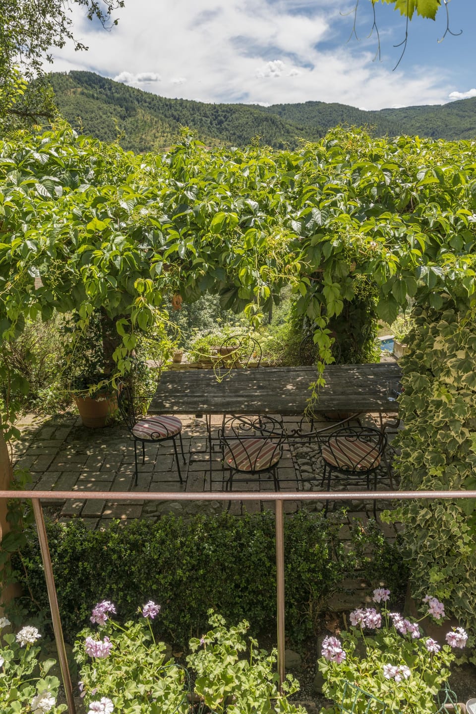Looking onto dining terrace from kitchen porta finestra. Pool beyond.