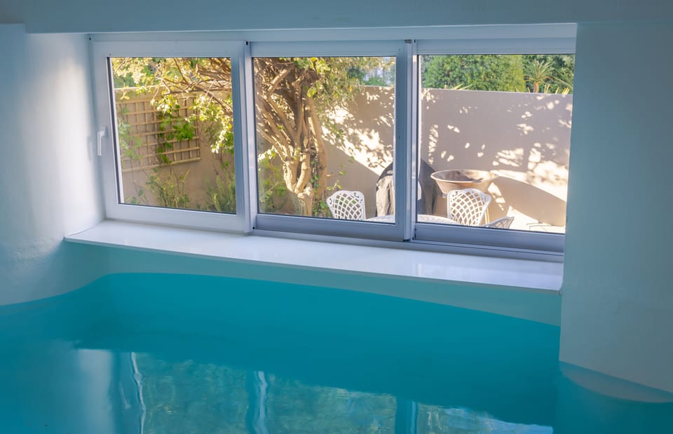 Heated indoor pool with windows opening to courtyard. 