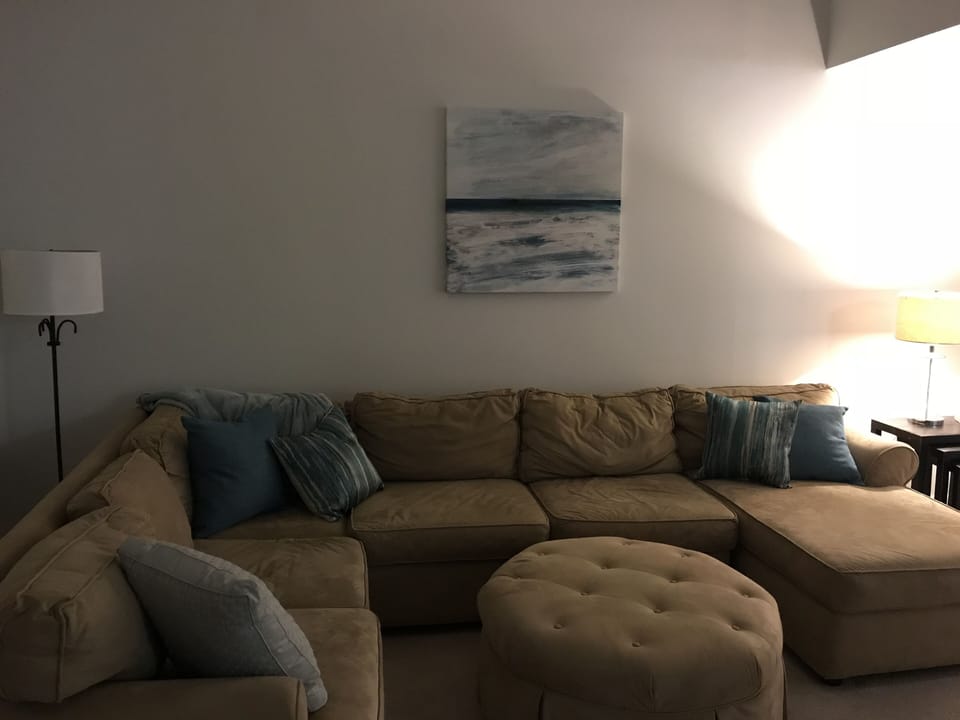 Cozy living room with television and access to deck overlooking pond. 
