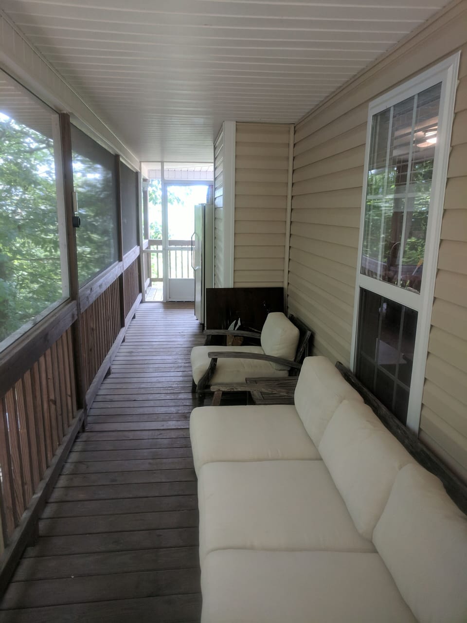 Screened in porch couch seating and outside fridge