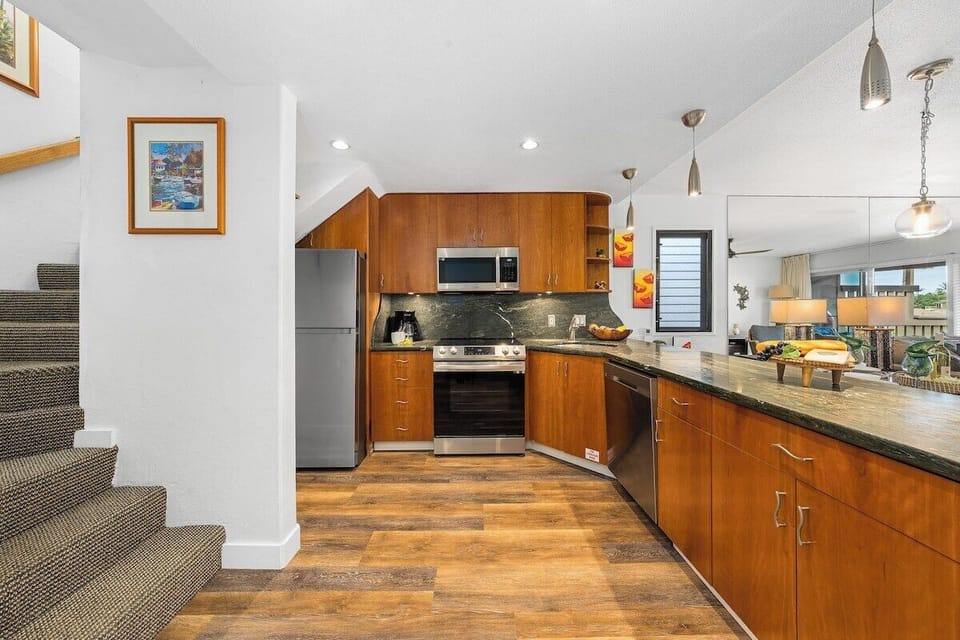 Fully equipped kitchen with wooden cabinetry, modern appliances, and open layout for easy meal prep.