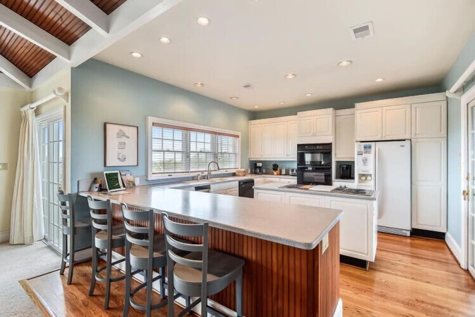 You'll love cooking and gathering in this spacious, light-filled kitchen with its generous island seating, modern appliances, and beautiful wood accents that blend style with comfort.