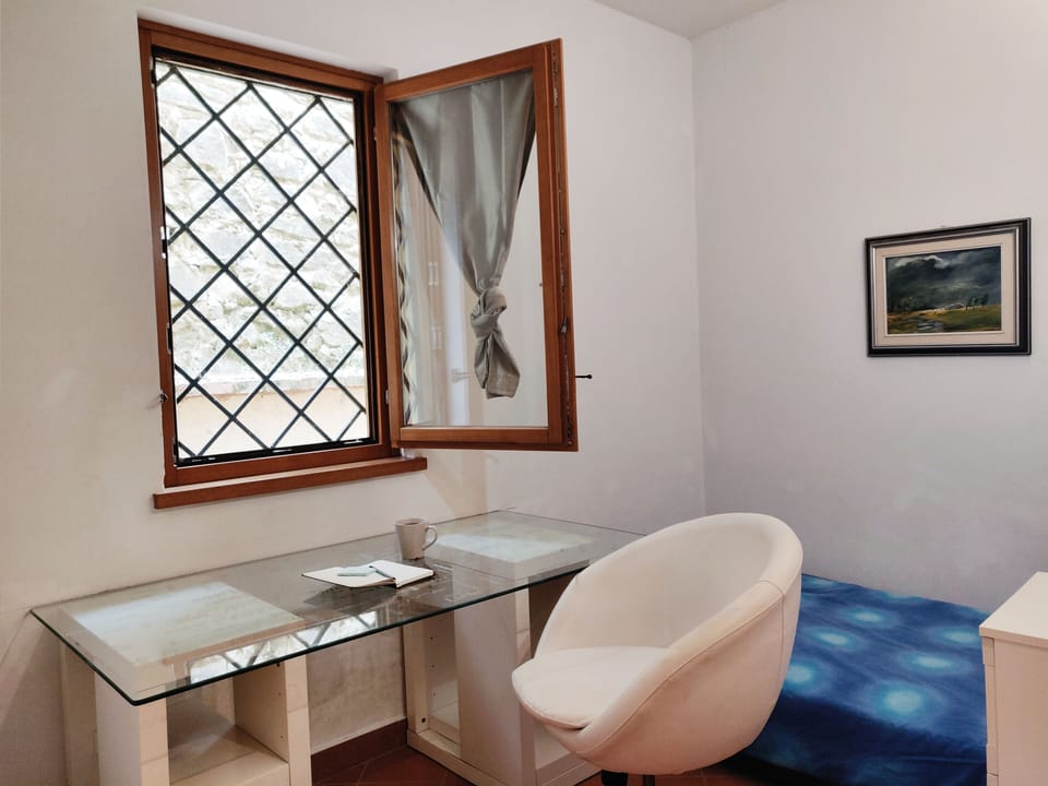A lovely single bedroom with a glass desk, bright window and wardrobe