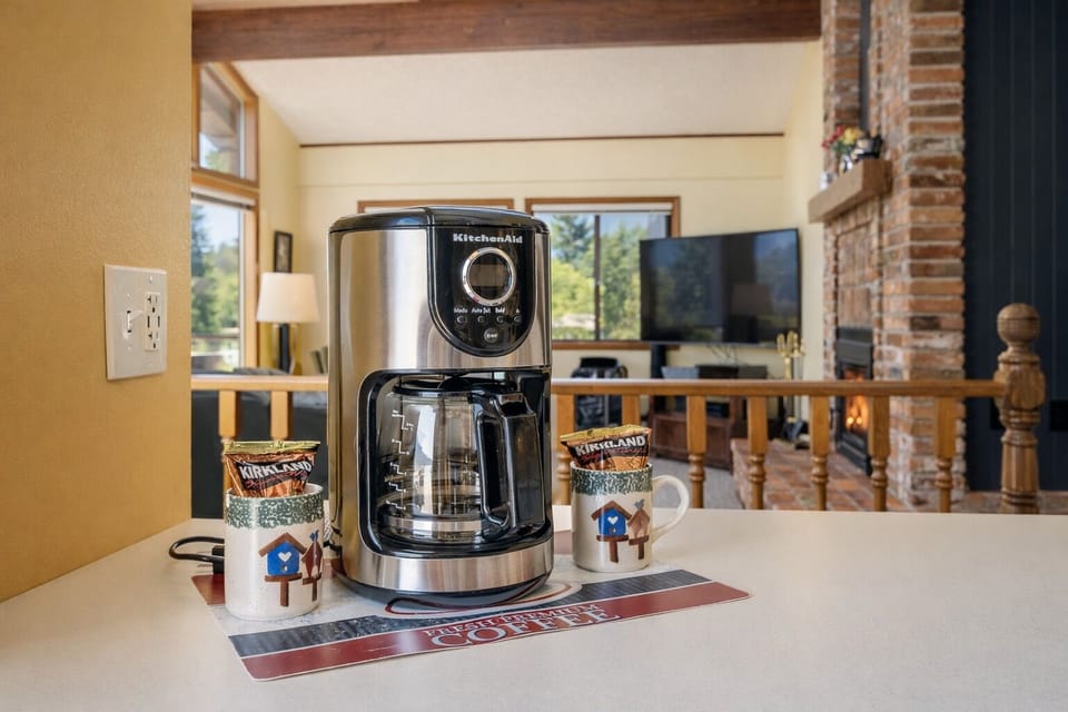 Start your mornings right with your own KitchenAid coffee maker, complete with fresh coffee and charming mugs in this cozy kitchen space.