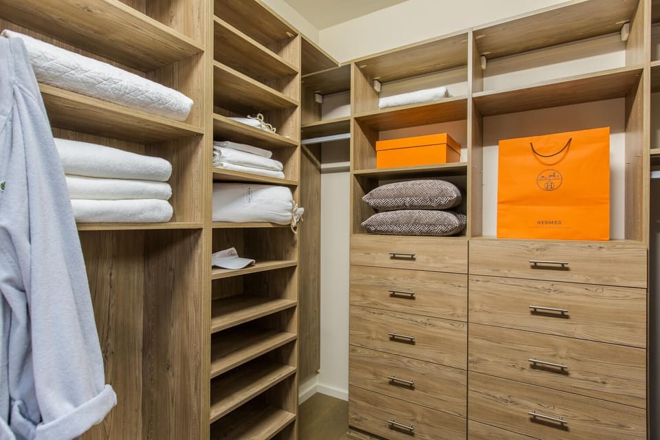 Unpack and stay organized in the spacious walk-in closet with custom shelving, designed for extended stays in style.