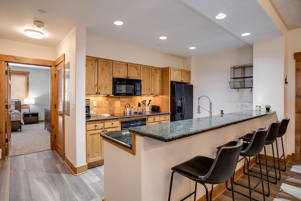 Your spacious kitchen features granite countertops, full appliances, and a breakfast bar perfect for morning coffee or evening conversations.