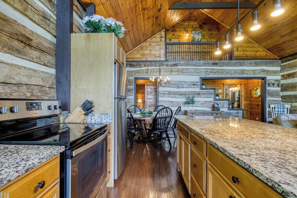 Open kitchen with cookware, fridge, and mountain charm
