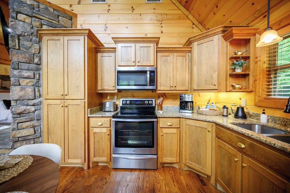 Your rustic cabin kitchen blends warm wood cabinetry with modern appliances, creating the perfect space for preparing mountain meals together.
