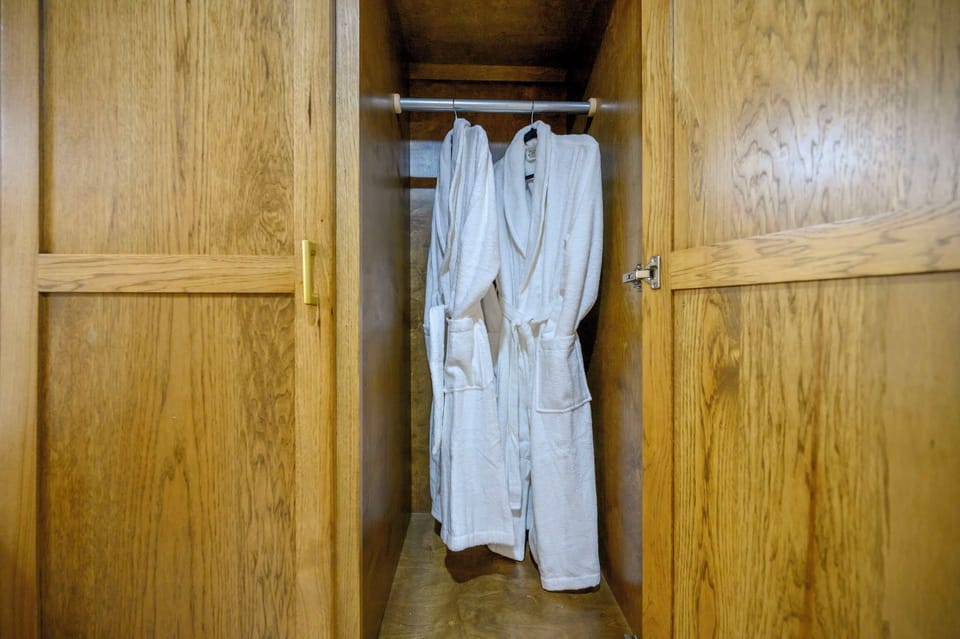 Your luxurious bathrobes await in this beautiful wooden wardrobe, ready to wrap you in comfort after your shower.