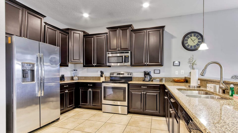 Full sized family kitchen with mahogany cabinets and granite counters.