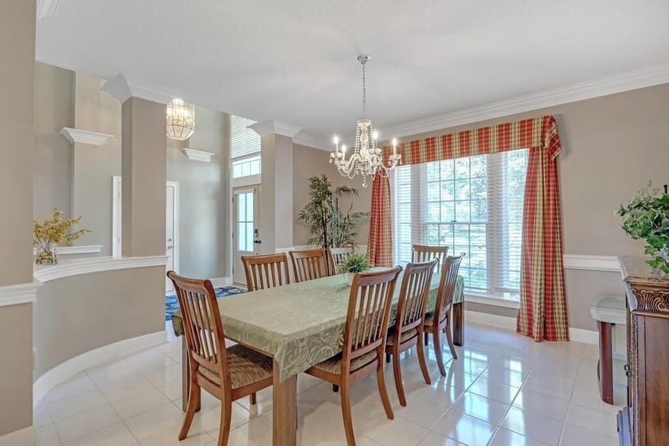 - Warm and welcoming dining area with elegant wood seating and bright natural window views
- Dual chandeliers and red accented curtains add charm to every shared meal experience
- Whether brunch or dinner, this space invites comfort and connection