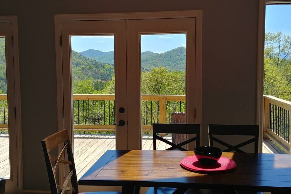 Dining area with seating for eight, featuring a table for six and island bar seating for two. This bright space offers high ceilings, abundant natural light, and a beautiful view of the mountains.