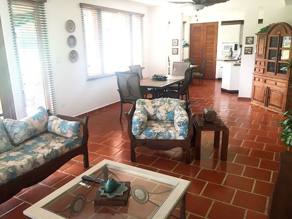 Living-room is furnished with deep-cushion upholstery on wooden armchairs