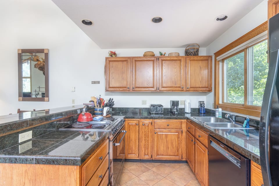 Fully equipped kitchen includes plentiful stioneware, flatware, glassware & more