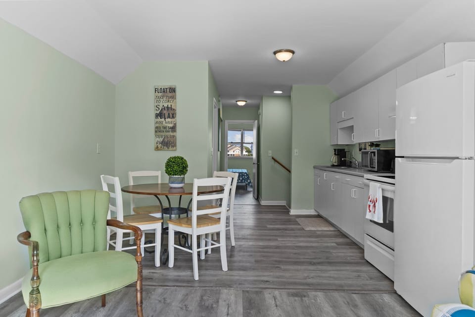 Your open kitchen and dining area invites leisurely meals with calming green walls and modern appliances at your fingertips.