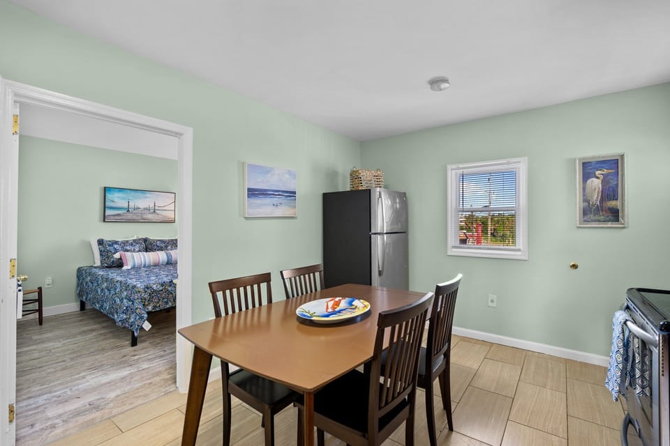Gather around your dining table for meals while soft mint walls and coastal artwork create a calming atmosphere.