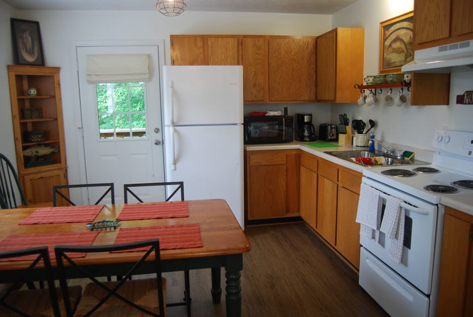 Kitchen has full size appliances and plenty of cookware, dishes and utensils.