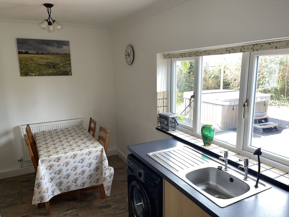 kitchen dining area showing table and chairs etc and window view of jacuzzi