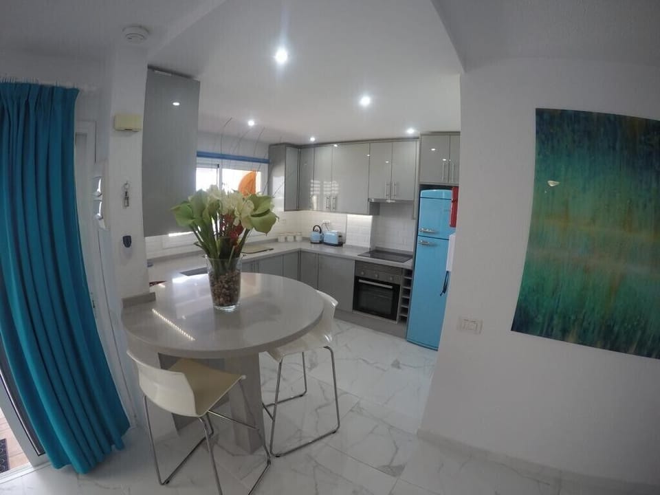 Open plan kitchen with built in microwave, electric oven and hob, breakfast bar