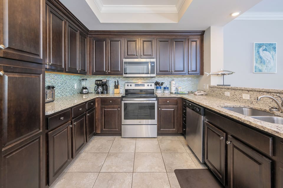 Prepare meals in this kitchen with elegant cabinetry, stainless appliances, and stylish backsplash