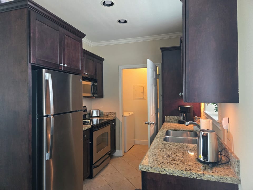 View of kitchen and small laundry room with full size washer and dryer!