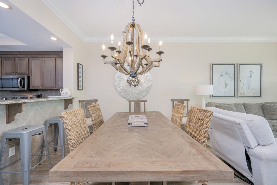 Delight in casual gatherings around the inviting dining table, enhanced by warm coastal decor and stylish lighting
