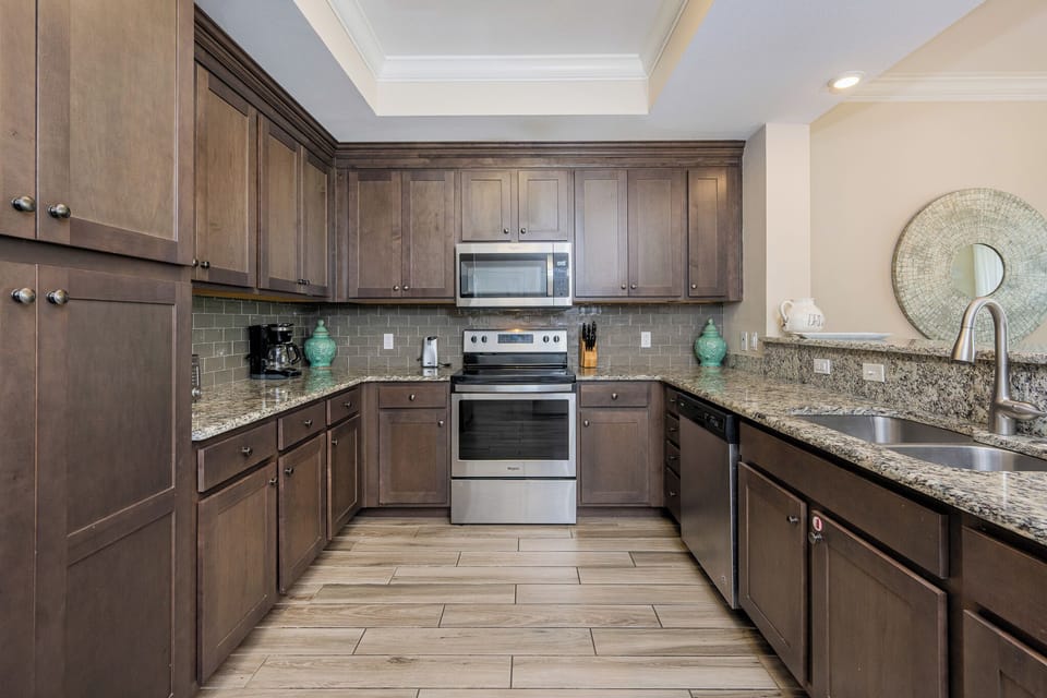 Prepare meals in this kitchen with elegant cabinetry, stainless appliances, and stylish backsplash