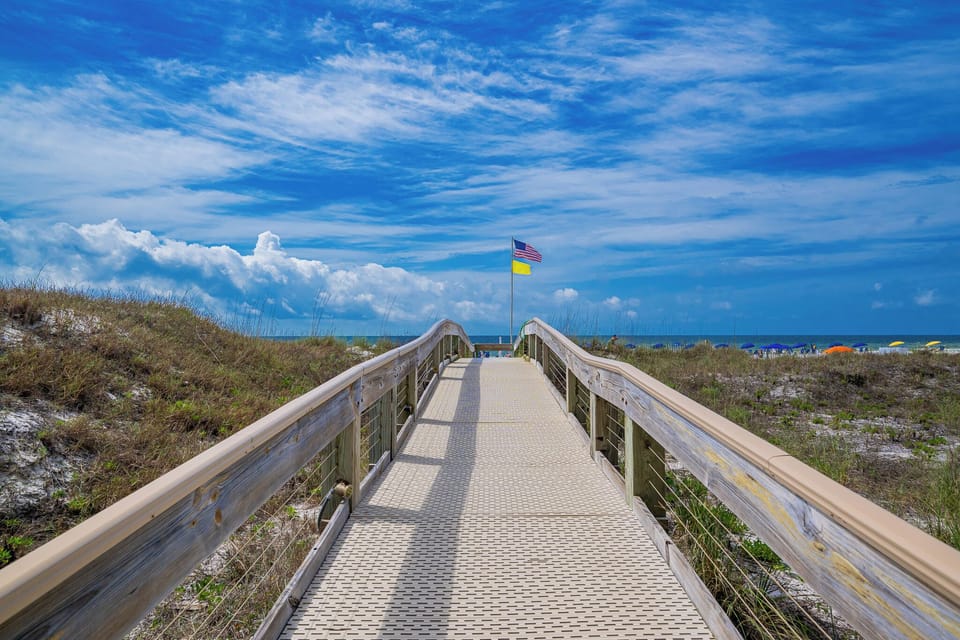 Walk along the scenic boardwalk leading to the beach at Phoenix V on the Alabama Gulf Coast to discover a new beach adventure