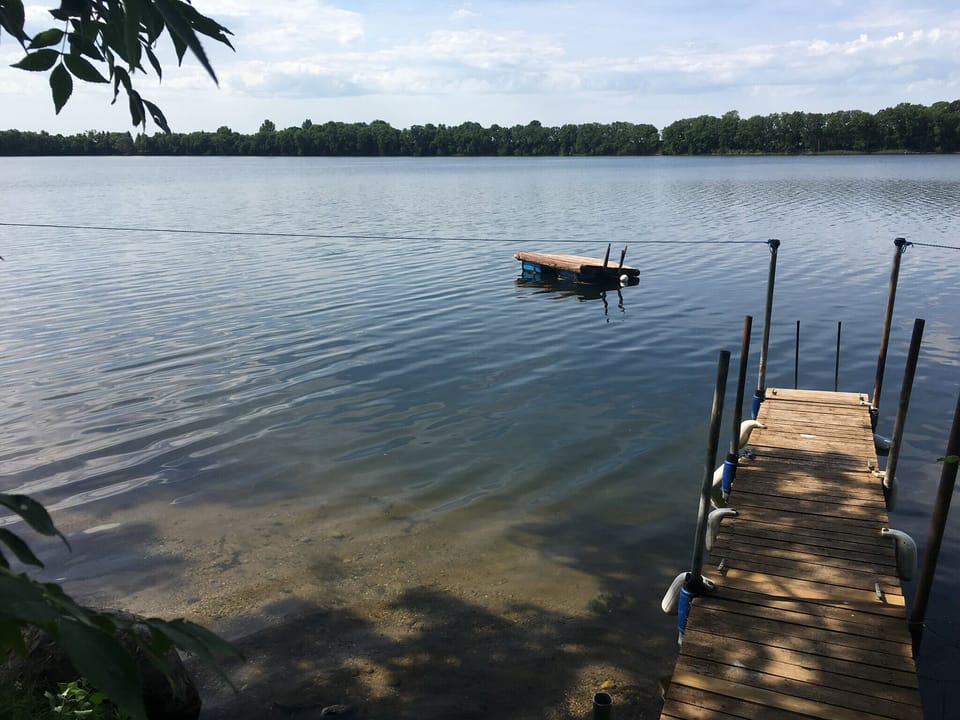 Sandy beach accessible by dock or steps and swimming platform
