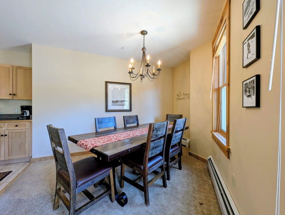 Gather around this inviting dining table where natural light and warm wood accents create the perfect setting for your morning coffee or evening meals with loved ones.