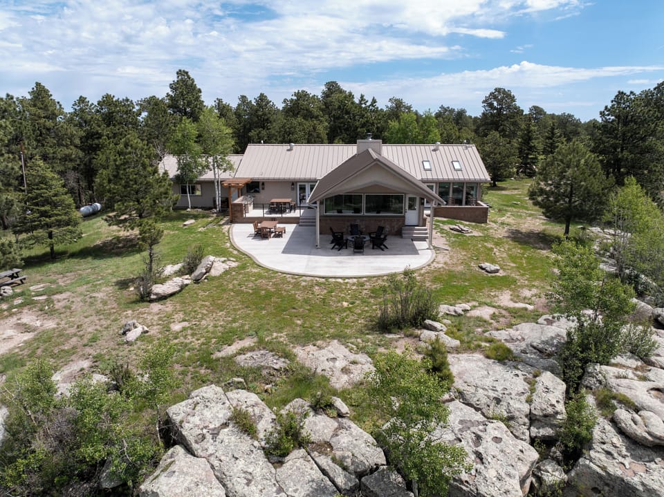 Home nestled among pines and rock outcrops for added privacy.