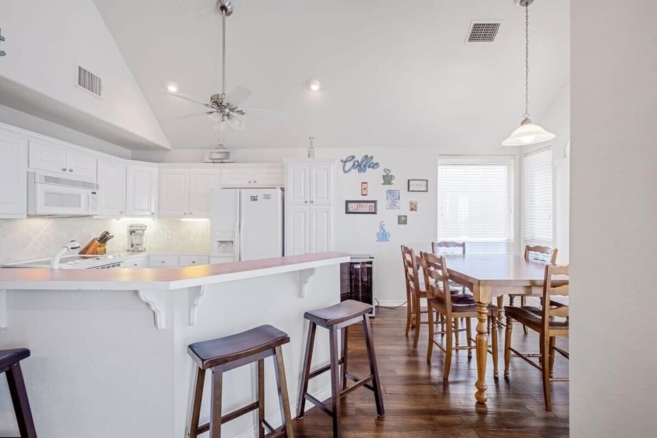 Dining area 6 seats at table with additional seats at the bar area.