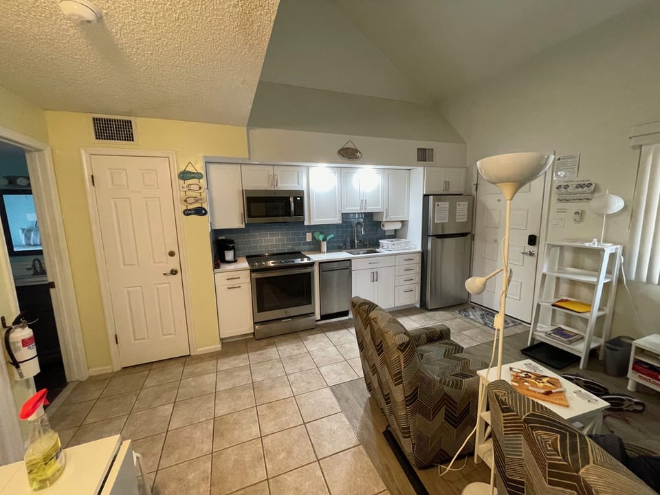 View of part of dining table, kitchen and living area
