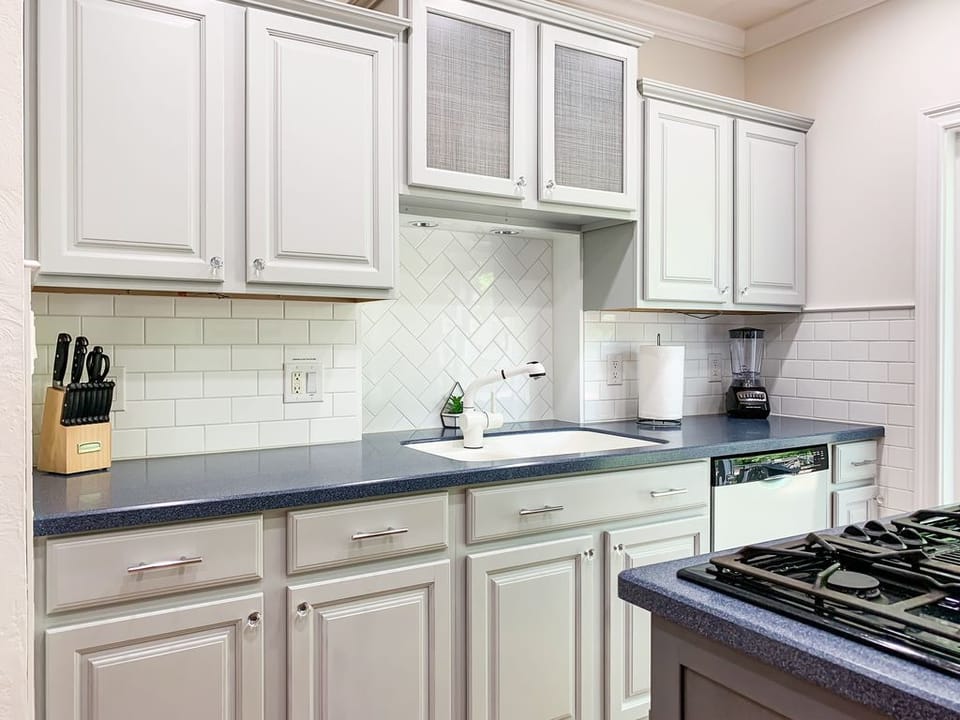 Bright and open kitchen with abundant counter space, cooking tools, dishwater and appliances.