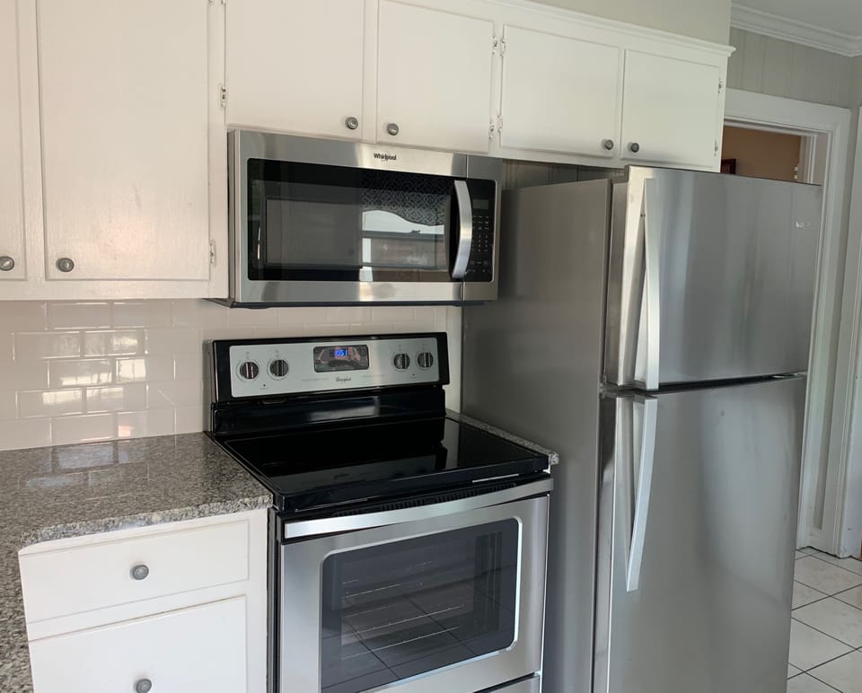 Kitchen with new granite counter tops, stove, microwave, dishwasher, and refrig