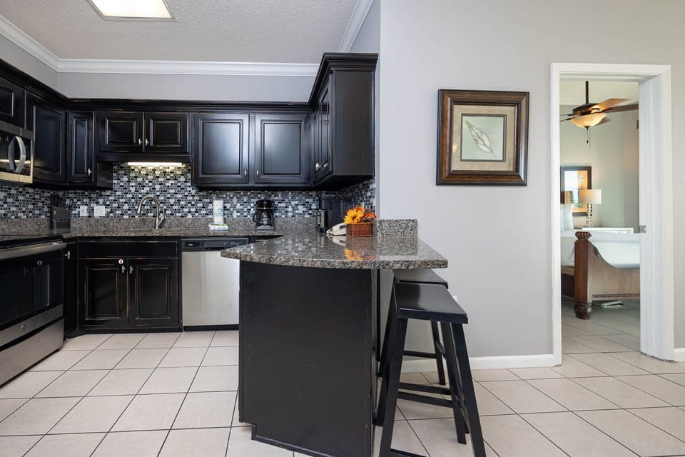 Prepare meals in the stylish kitchen featuring sleek black cabinets, granite countertops, and stainless appliances