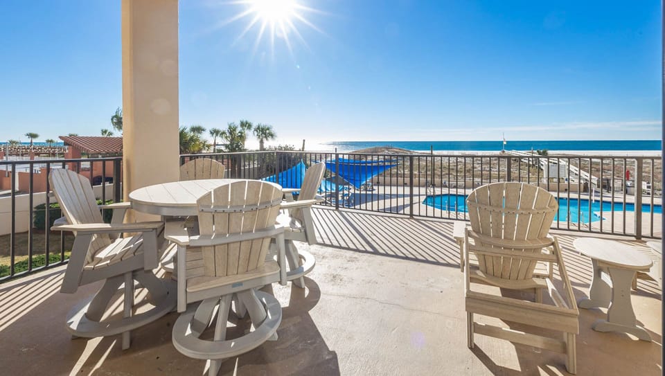 Relax on the spacious beachfront balcony, enjoying views of the pool and the shimmering beach beyond