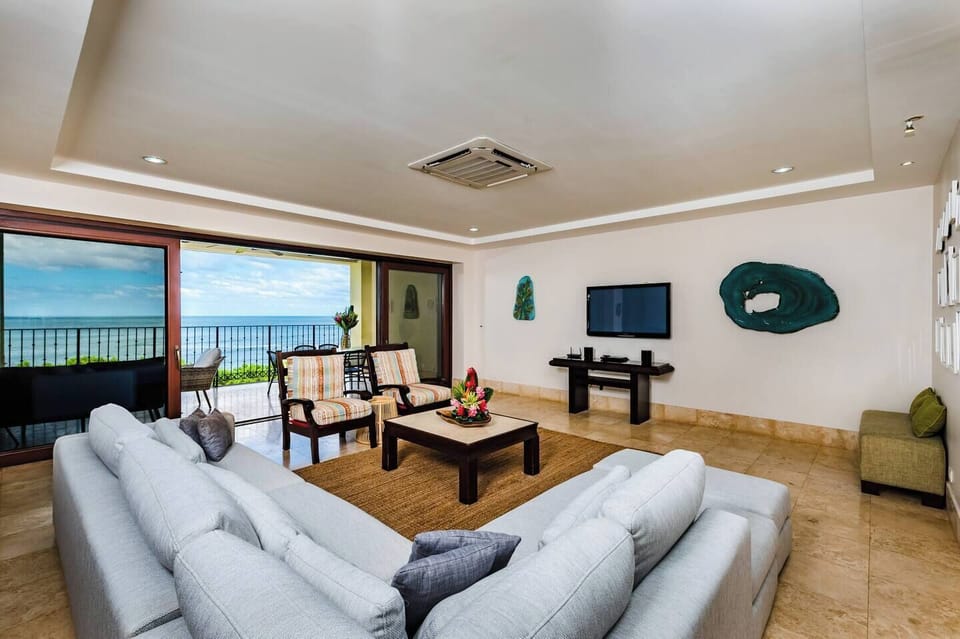 Spacious ocean-view living room with elegant furnishings, natural light, and seamless access to the beachfront balcony. Perfect for families or couples seeking a Tamarindo luxury rental steps from Langosta Beach and top surf spots.