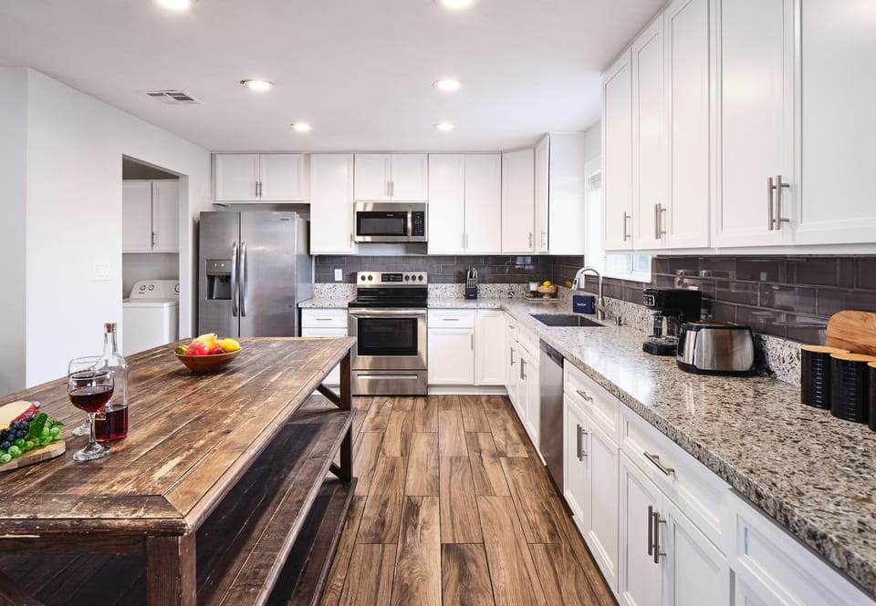 Fully-equipped kitchen with stainless steel appliances, basic cooking essentials, and a big kitchen island.