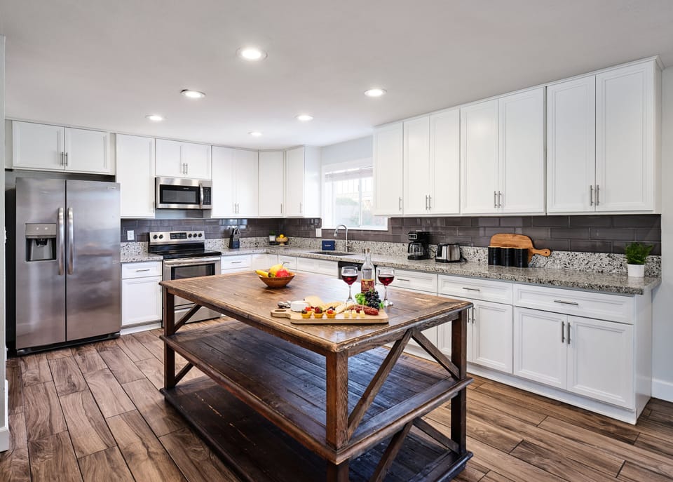 Fully-equipped kitchen with stainless steel appliances, basic cooking essentials, and a big kitchen island.