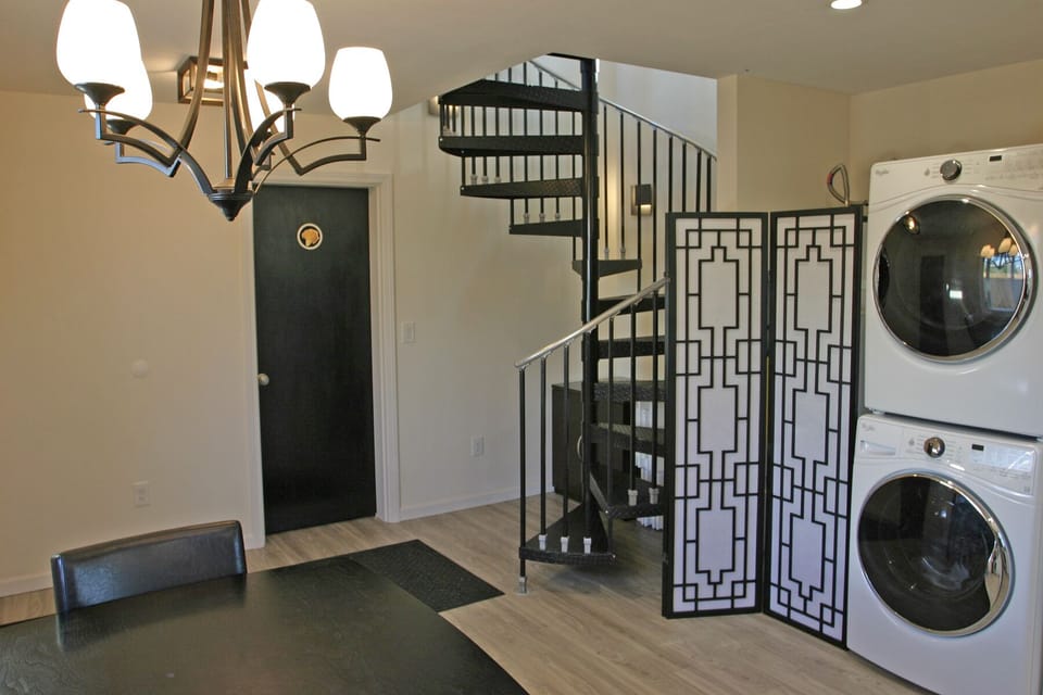 Black entry door to Shroom Suite, staircase up to Perch Suite & Summit Suite