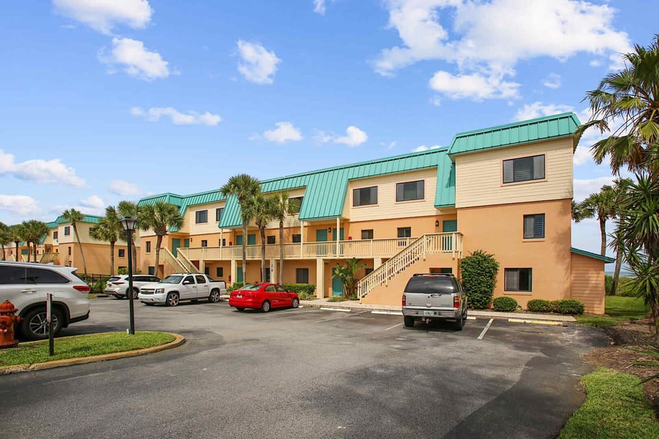 - Convenient parking right outside the building for easy access  
- Bright exterior with coastal colors welcomes you upon arrival  
- Simple entry setup ensures a smooth start to your beach getaway  
