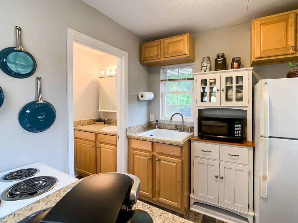 Compact kitchen thoughtfully equipped with a full-size fridge, 4 burner stove, breakfast bar and everything you need to prepare meals.